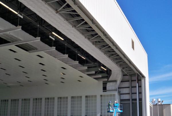 Exterior of Gulfstream Paint Hangar. Large white building 和 blue sky.