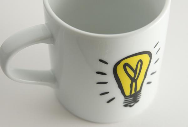 白色杯子，白色背景. Idea symbol is on the mug.