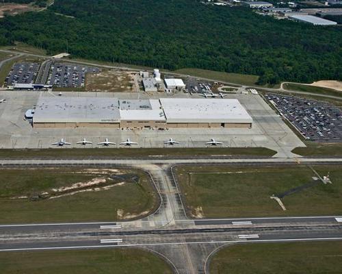 Aerial view of Gulfstream Service Center. 长方形的建筑，周围是停车场和停放的飞机.